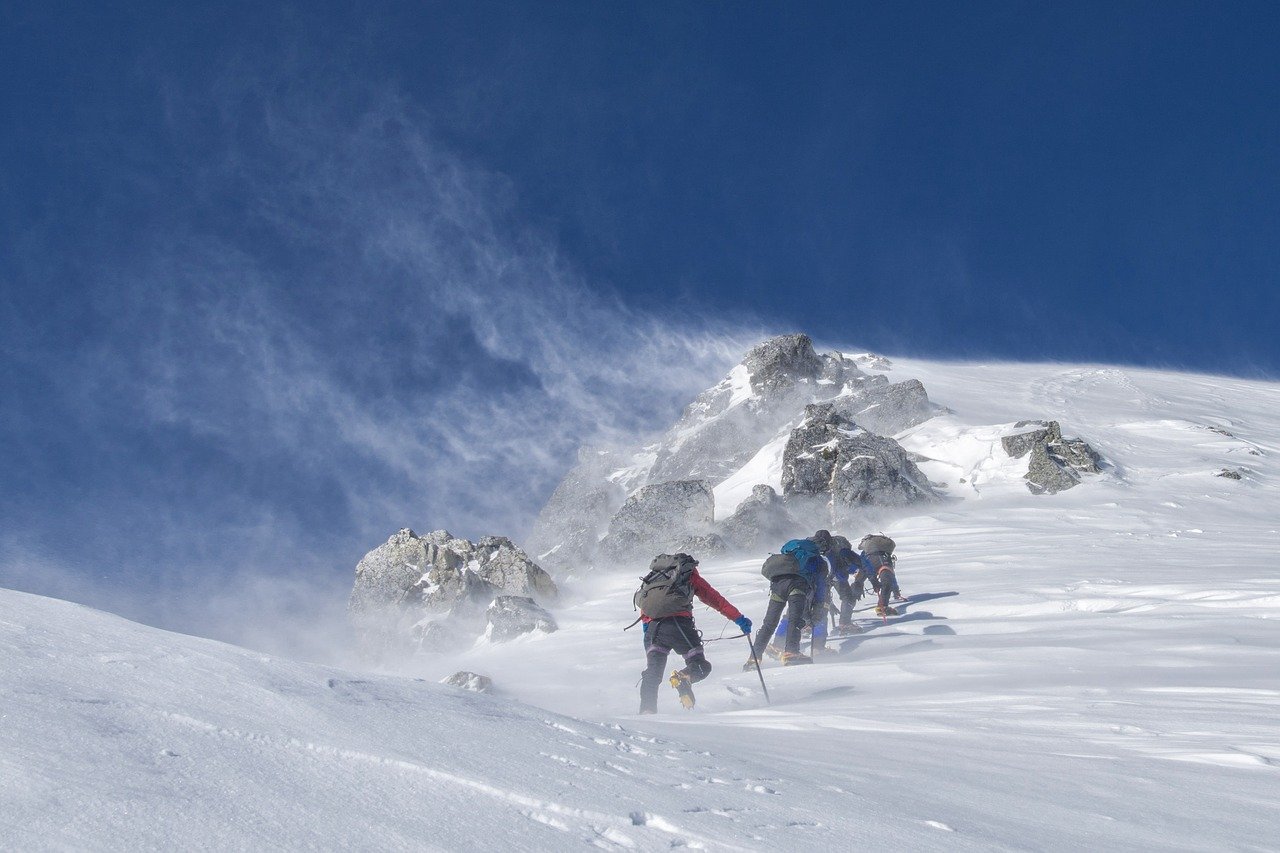 Beim Bergsteigen auf Gesundheit achten Gruppe von Bergsteigern erklimmt Gipfel Schnee
